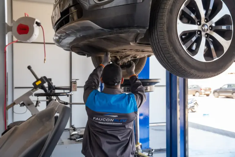 Homme travaillant sur une voiture dans un centre de services automobiles faucon bleu de nos métiers.